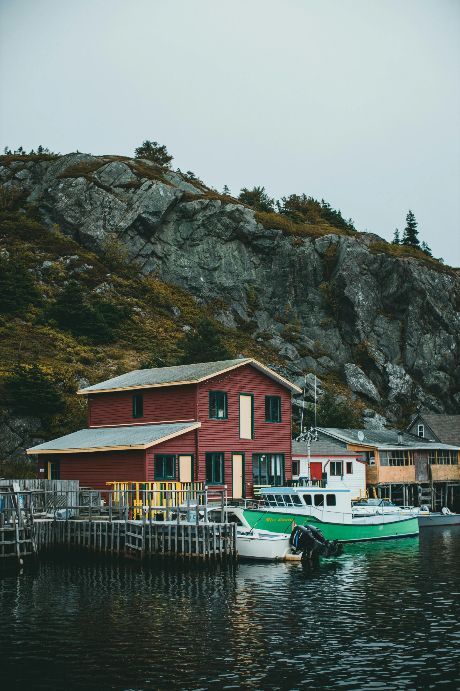 a couple of boats that are in the water, by Jessie Algie, pexels contest winner, small buildings, gauthier leblanc, craggy, exterior shot