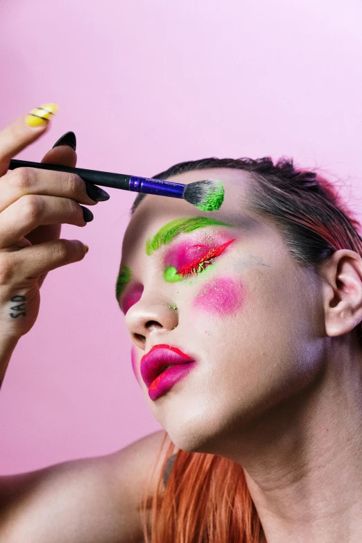 a woman is putting makeup on her face, an album cover, trending on pexels, pop art, an epic non - binary model, green and pink, “ painting, bella poarch