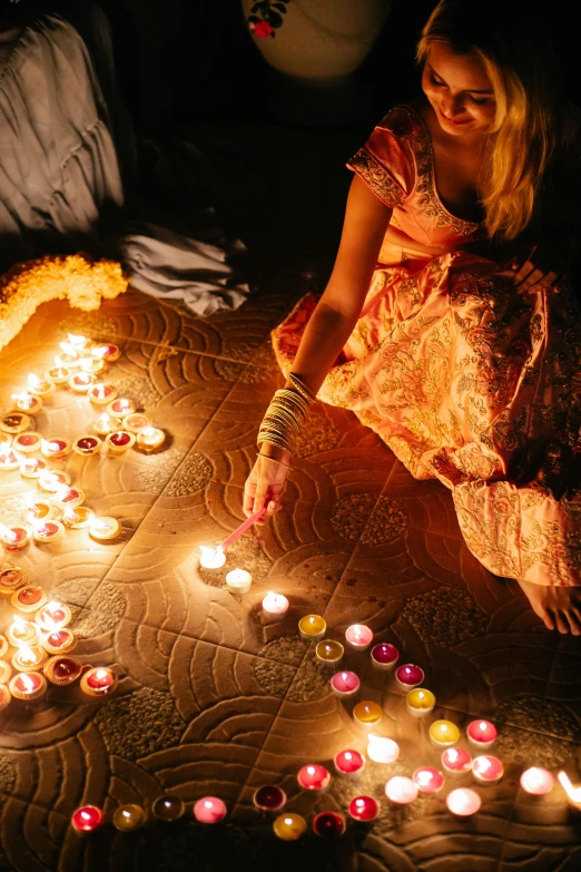 a woman lighting candles in the shape of a heart, pexels contest winner, light and space, indian patterns, lamps on ground, partylights, 2010s