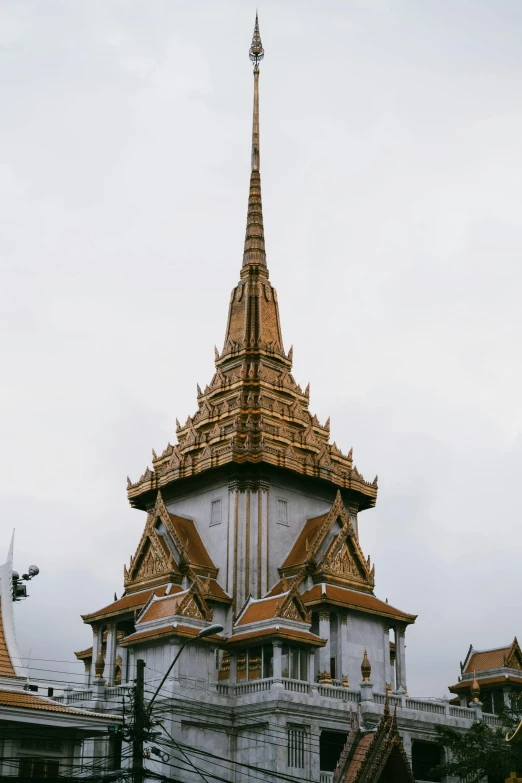 a large white building with a golden spire, bangkok, silver with gold trim, peaked wooden roofs, high-body detail