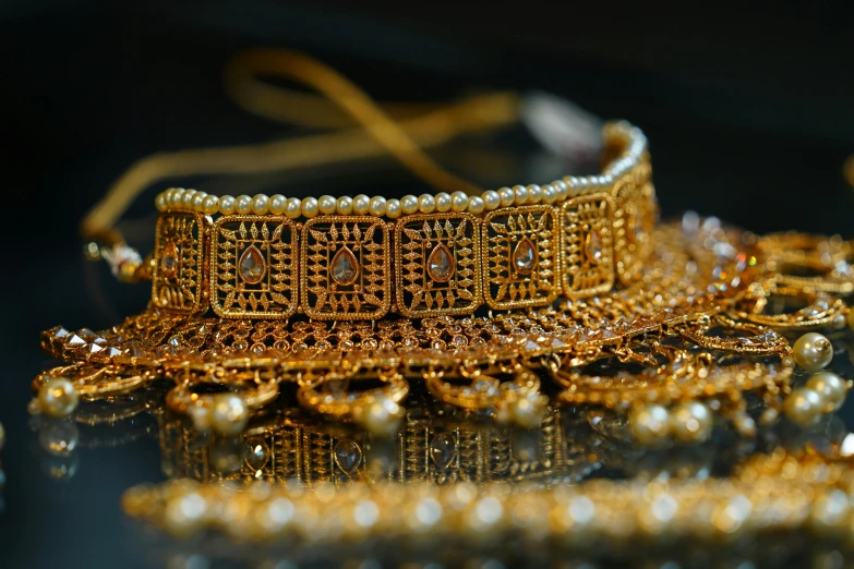 a close up of some gold jewelry on a table, pexels contest winner, hurufiyya, headpiecehigh quality, thumbnail, gold detailed collar, indian