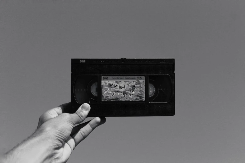 a black and white photo of a hand holding a video cassette, by Jan Kupecký, unsplash, video art, instagram post, abstract claymation, ad image, foto realista