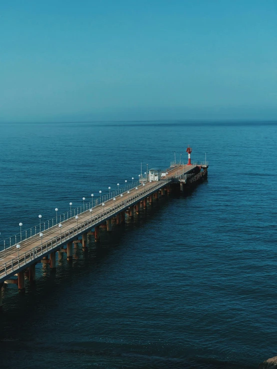 a long pier in the middle of a body of water, pexels contest winner, black sea, 4 k cinematic panoramic view, 2 5 6 x 2 5 6 pixels, aerial view cinestill 800t 18mm