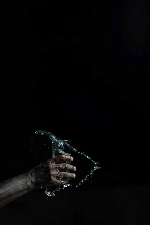 a man that is holding something in his hand, an album cover, by Adam Chmielowski, pexels contest winner, conceptual art, black water, thirst, 'untitled 9 ', ignant