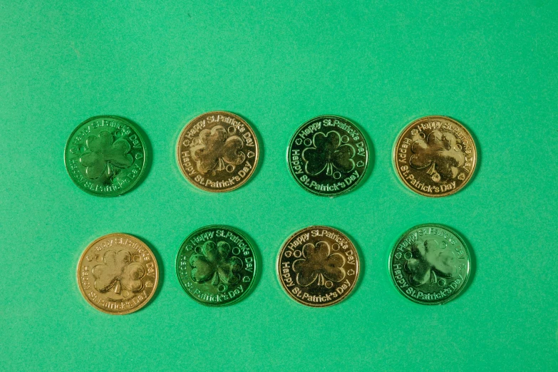 a bunch of coins sitting on top of a green surface, standing in gold foil, 35 mm product photo”, four leaf clover, fruit machines