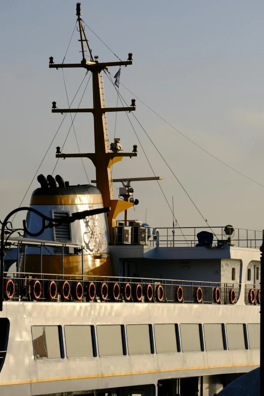 a large boat sitting on top of a body of water, a portrait, up close shot, from the distance, portholes, late afternoon