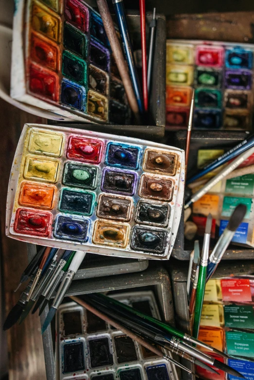 a wooden box filled with lots of watercolor paints, a watercolor painting, inspired by Max Weber, trending on unsplash, inside a grand messy studio, 🎨🖌️, traditional art, multicolor