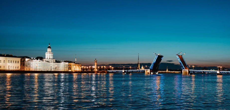 a bridge over a body of water with a building in the background, by Julia Pishtar, saint petersburg, ultrawide image, blue night, slide show