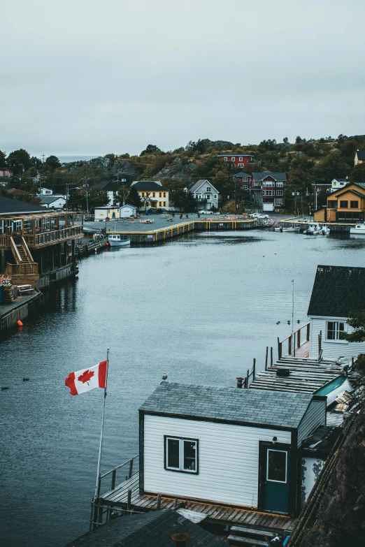 a large body of water filled with lots of boats, pexels contest winner, cottage town, canada, moody aesthetic, low quality photo