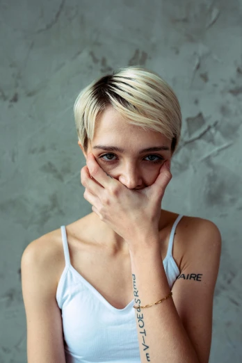 a woman covering her face with her hands, an album cover, inspired by Elsa Bleda, trending on pexels, hyperrealism, pixie undercut hairstyle, young angry woman, zoe kazan, !female