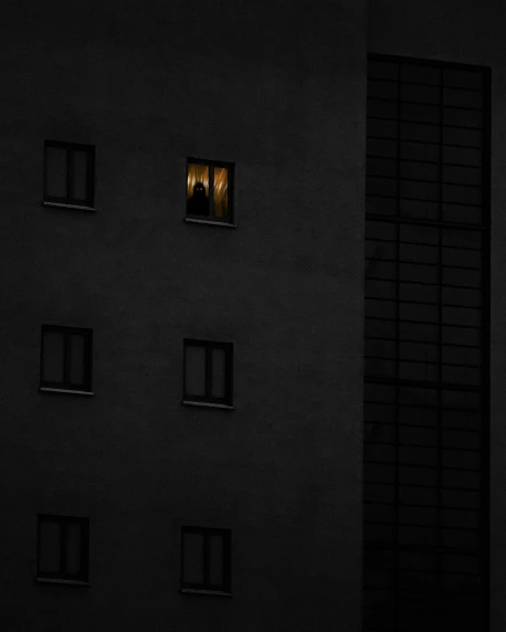 a person looking out of a window at night, an album cover, by Tobias Stimmer, unsplash contest winner, conceptual art, dark building, gold, sergey zabelin, minimalist photo