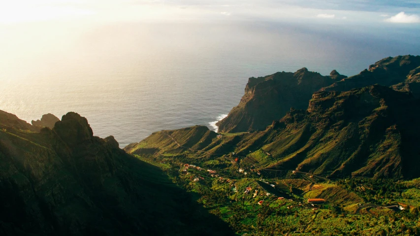 a view of the ocean from the top of a mountain, by Daniel Lieske, pexels contest winner, farming, warm light, green ocean, “ aerial view of a mountain