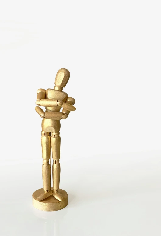 a gold figurine standing on a white surface, by Gavin Hamilton, pixabay contest winner, new sculpture, father with child, robotics, hugging, awardwinning movie still