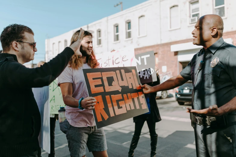 a group of people holding signs in a parking lot, trending on pexels, feminist art, fights, gay, lachlan bailey, profile image