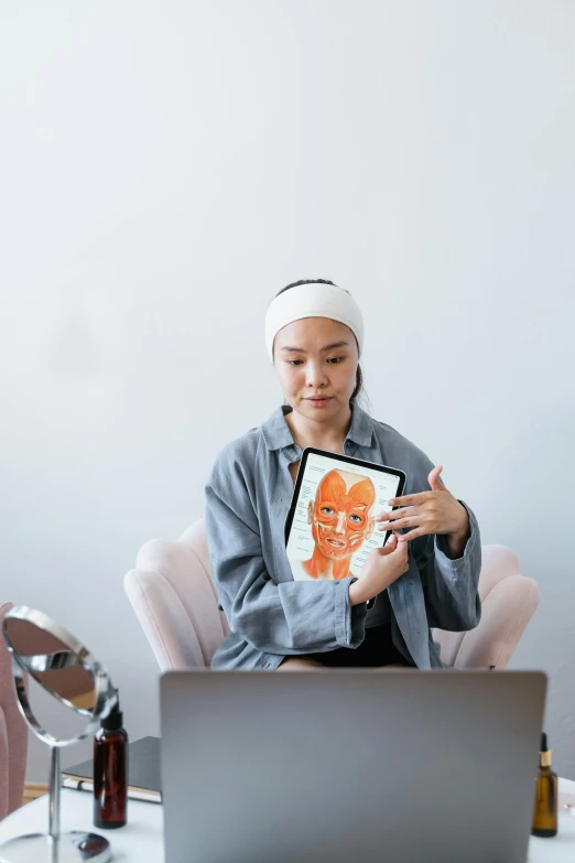 a woman sitting in front of a laptop computer, by Julia Pishtar, trending on pexels, analytical art, asian face, silicone skin, holding a book, symetrical facial