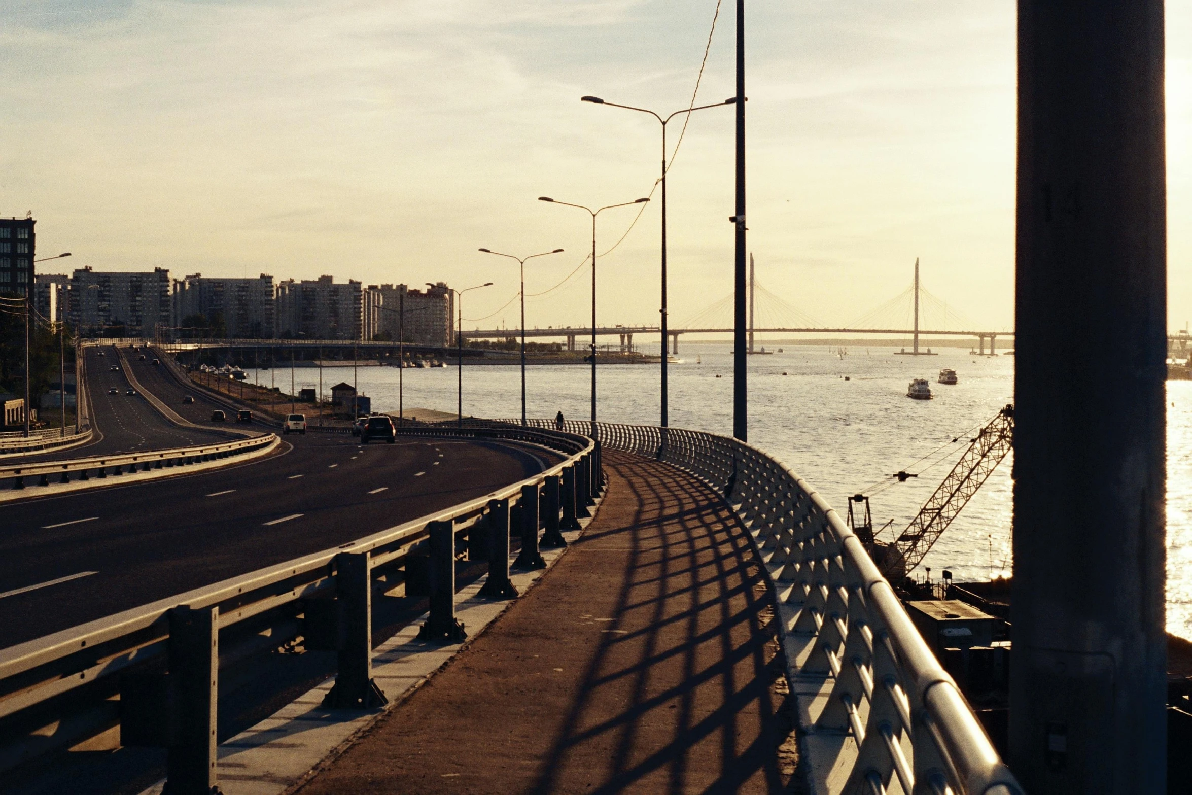 a view of a bridge over a body of water, by Ceferí Olivé, pexels contest winner, sun and shadow over a city, avenida paulista, road to the sea, 90s photo