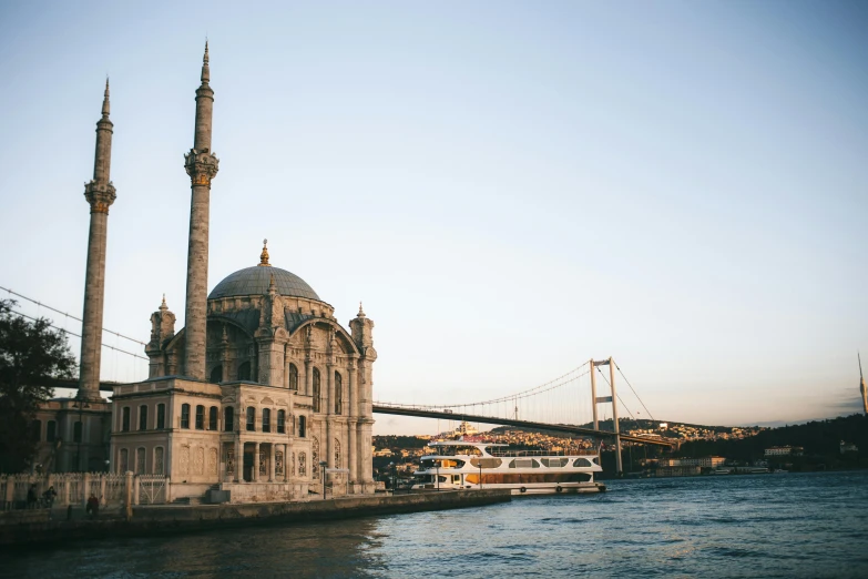 a large building sitting on top of a river next to a bridge, pexels contest winner, hurufiyya, ottoman empire era, harbor, conde nast traveler photo, brown