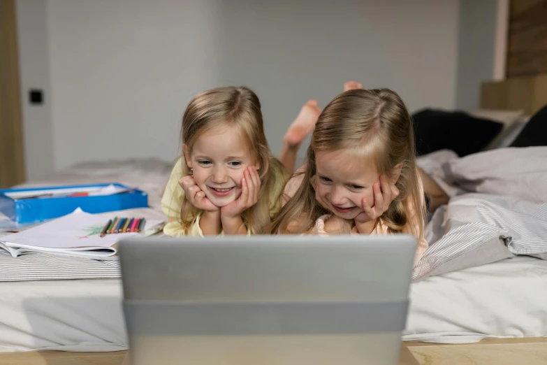 a couple of little girls laying on top of a bed, pexels contest winner, incoherents, typing on laptop, jajaboonords flipjimtots, avatar image, super high resolution