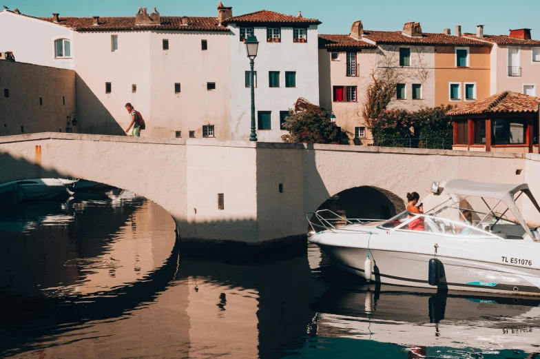 a couple of boats that are in the water, pexels contest winner, les nabis, lourmarin, on a bridge, 🦩🪐🐞👩🏻🦳, in the style wes anderson