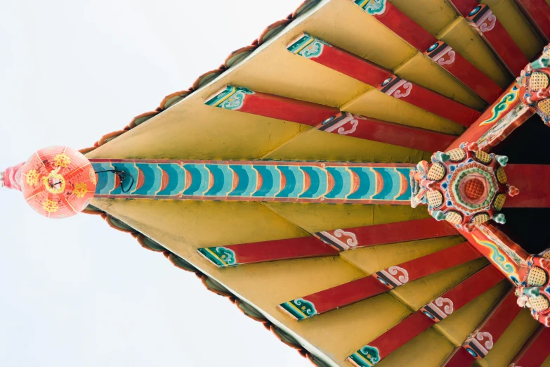 a red and yellow roof with a blue sky in the background, an ultrafine detailed painting, unsplash contest winner, cloisonnism, intricate triangular designs, detailed shot legs-up, overhead canopy, south east asian with long