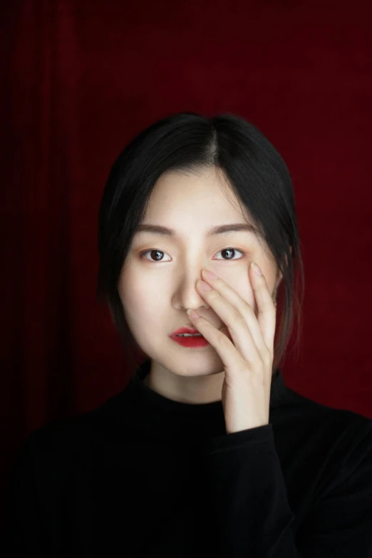 a woman holding her hand to her face, an album cover, inspired by Yu Zhiding, pexels contest winner, hyperrealism, red round nose, gongbi, headshot profile picture, square nose