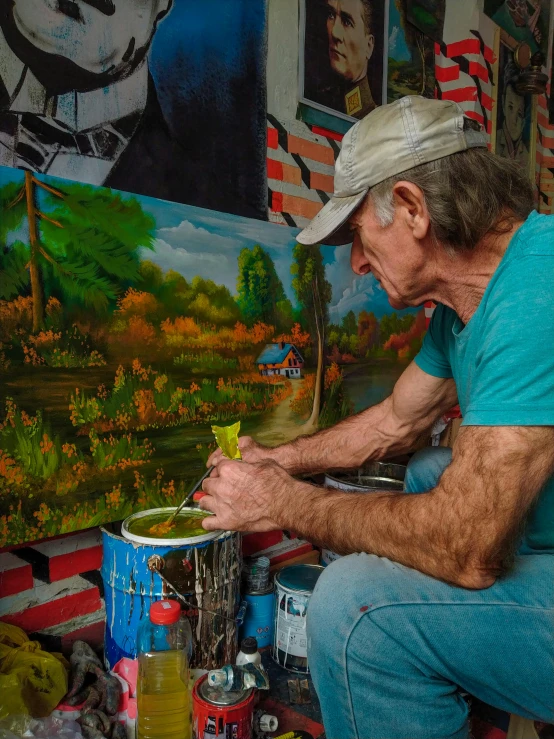 a man sitting on a stool in front of a painting, by Arnie Swekel, pexels contest winner, american scene painting, scene from louisiana swamps, americana vibrant colors, holding a paintbrush in his hand, gardening