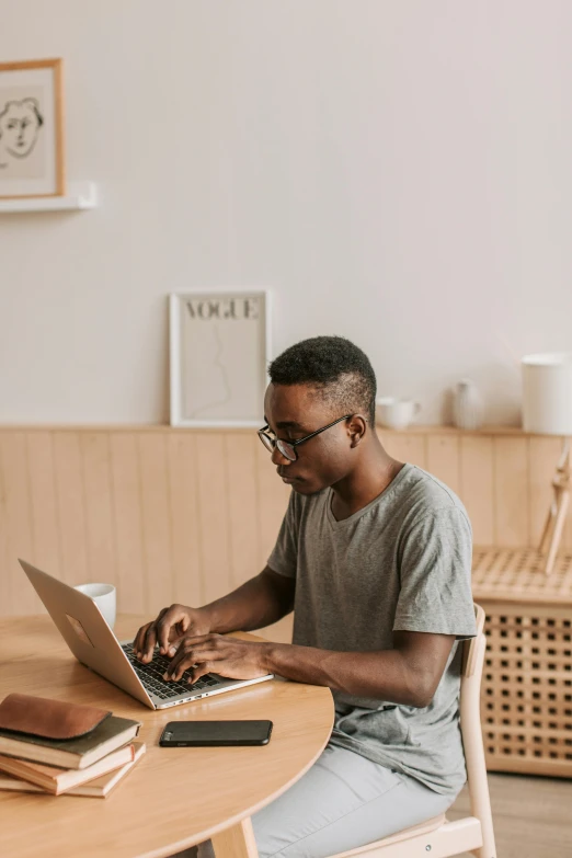 a man sitting at a table using a laptop, trending on pexels, ashteroth, ignant, sitting on a mocha-colored table, craigslist photo