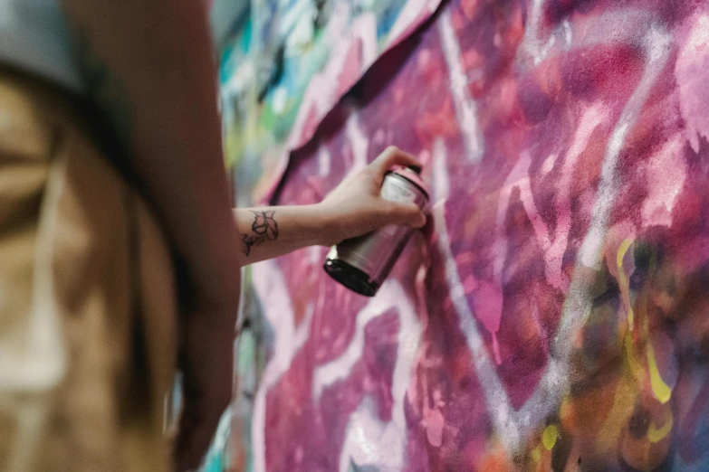 a person spraying graffiti on a wall with a spray can, pexels contest winner, graffiti, watercolors on canvas, female emo art student, metallic paint, medium [ graffiti ]