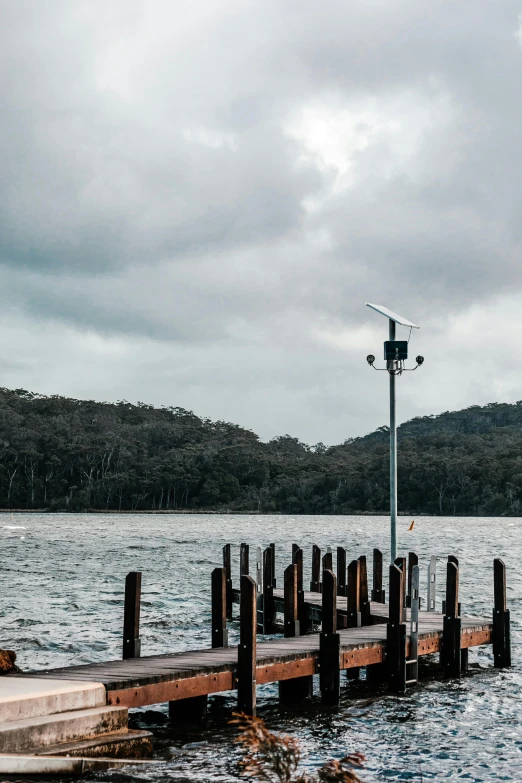 a dock in the middle of a body of water, rain sensor, in australia, lampposts, large environment