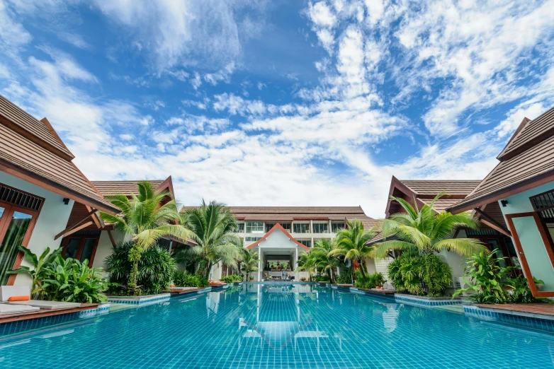 a swimming pool in the middle of a resort, by Aya Goda, unsplash, maroon, avatar image, exterior photo, wide frontal view