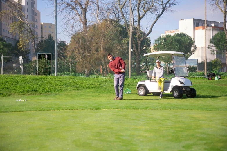 a man standing next to a golf cart on a green field, lisbon, avatar image