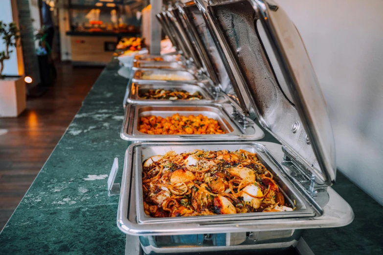 a row of trays of food sitting on top of a counter, profile image, cuisine