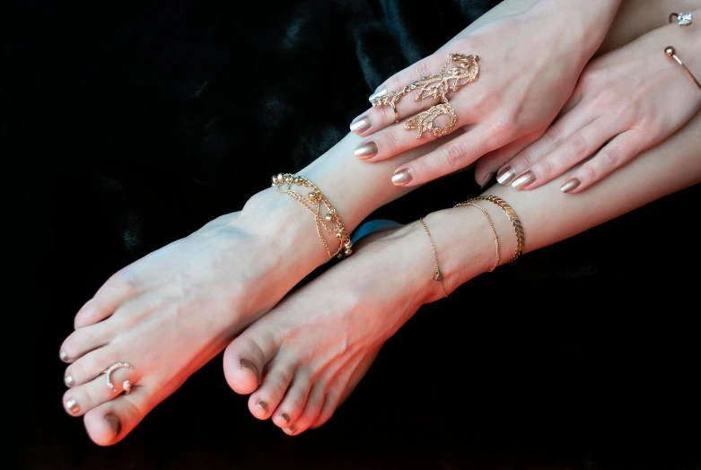 a close up of two feet with rings on them, an album cover, inspired by Victorine Foot, trending on pexels, arabesque, brass bracelets, oriental fantasy, made in gold, 5 fingers). full body realistic
