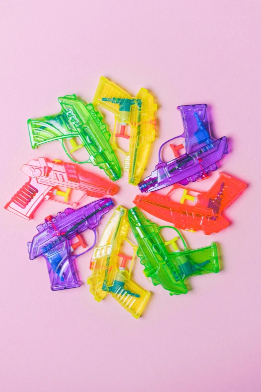 a bunch of plastic hair clips on a pink surface, inspired by Lisa Frank, pop art, holding a ray-gun, water jets, 8, mini