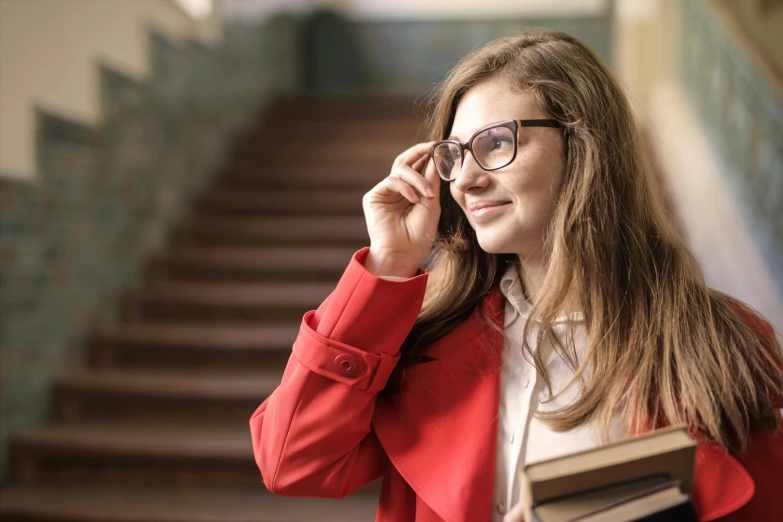 a woman talking on a cell phone while holding a book, trending on pexels, academic art, small square glasses, wearing red jacket, high school girls, girl with brown hair