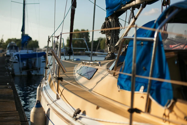 a sailboat docked at a dock with other boats in the water, a portrait, unsplash, close - up profile, thumbnail, maple syrup sea, sunny light