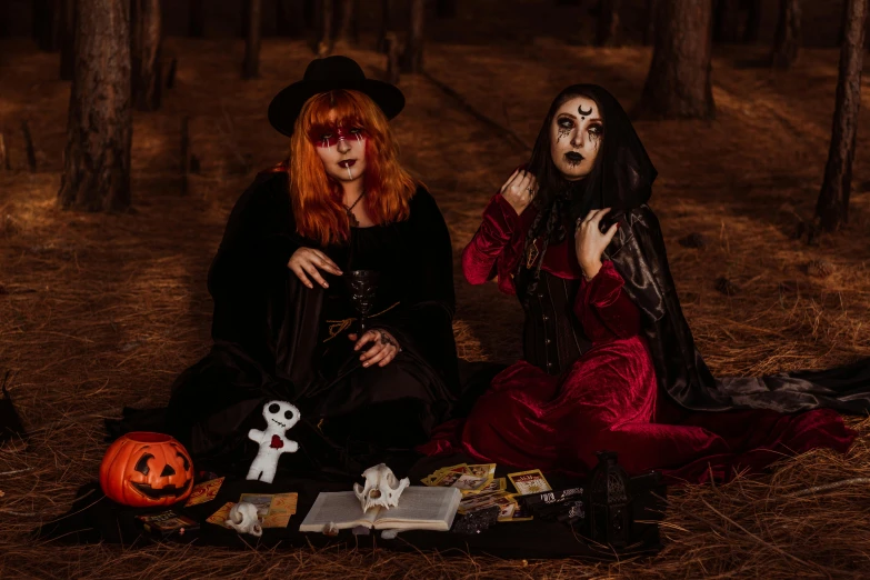 two women dressed in halloween costumes sitting on the ground, pexels contest winner, gothic art, tarot cards characters, forest picnic, spooky found footage, ying and yang