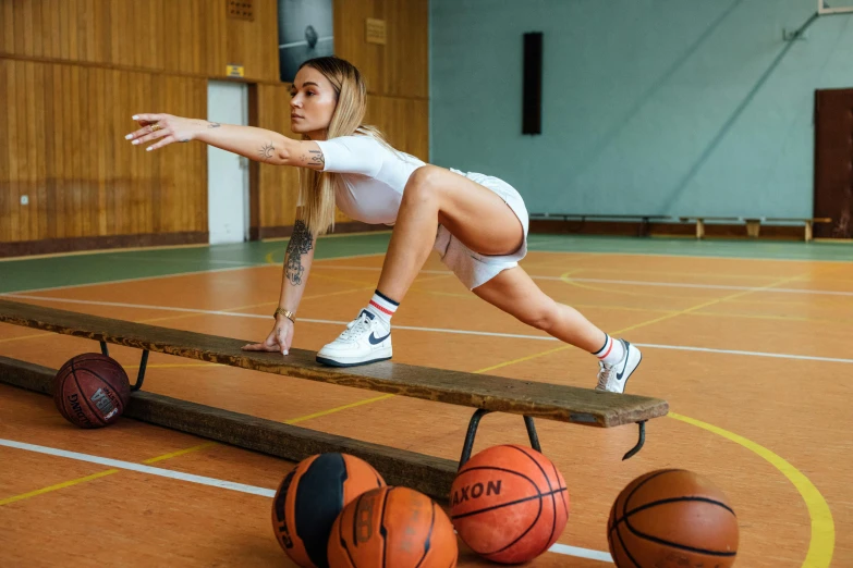 a woman sitting on top of a wooden bench, trending on dribble, playing basketball, wearing white leotard, in a gym, woman in streetwear