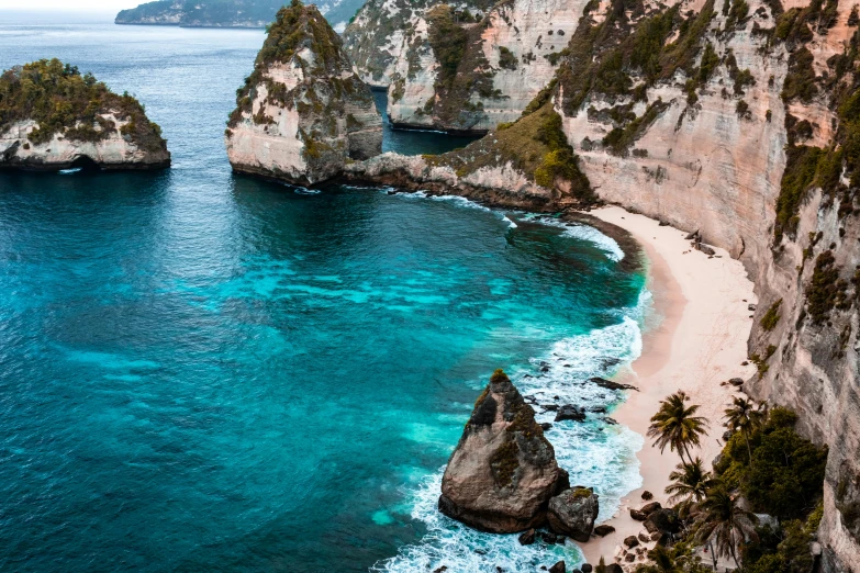 a large body of water next to a cliff, pexels contest winner, sumatraism, pink white turquoise, beaches, conde nast traveler photo, brown