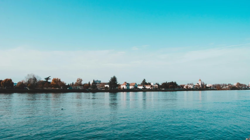 a body of water with houses in the background, pexels contest winner, clear sky, northern france, instagram photo, hd footage