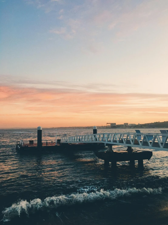 a couple of boats sitting on top of a body of water, happening, at the sunset, bondi beach in the background, trending on vsco, near a jetty