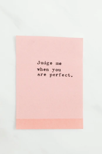 a pink post it note with the words judge me when you are perfect, by Dulah Marie Evans, dada, trading card front, display item, simple details, minna sundberg