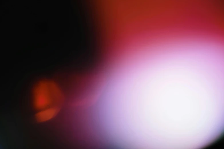a close up of a cell phone with a blurry background, by Jan Rustem, light and space, red haze, colour photograph, abstracted, red and purple