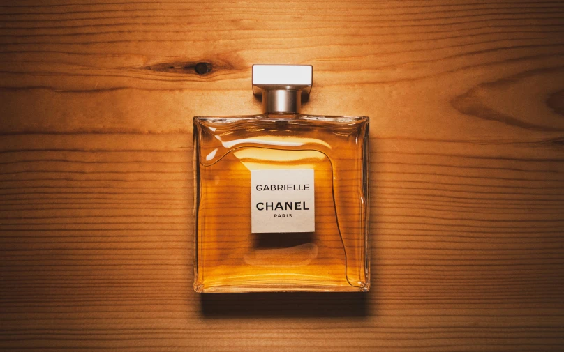 a bottle of chanel perfume on a wooden table, by Daniel Lieske, pexels contest winner, caramel. rugged, model kit, rectangle, nobel prize