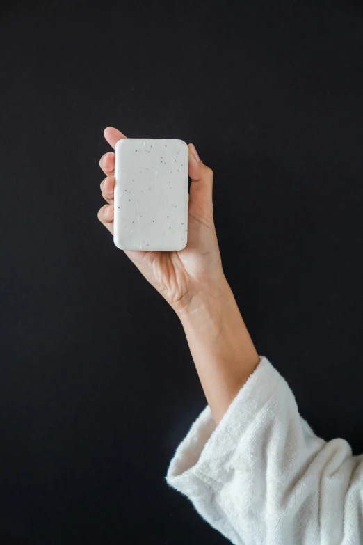 a woman in a bathrobe taking a selfie with her cell phone, unsplash, conceptual art, materials white stone, square, speckled, soap