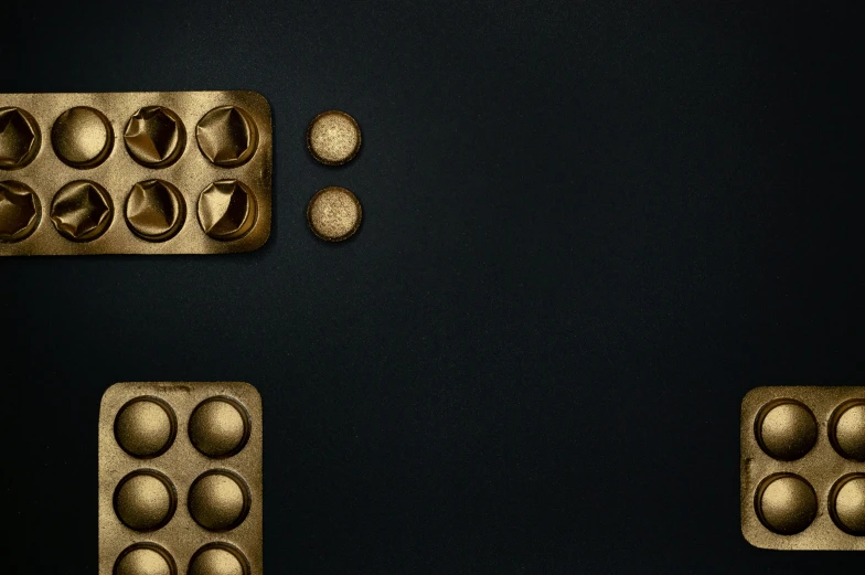 a couple of trays of food sitting on top of a table, inspired by Louise Nevelson, minimalism, metallic buttons, deep blue mood, gold, official product photo