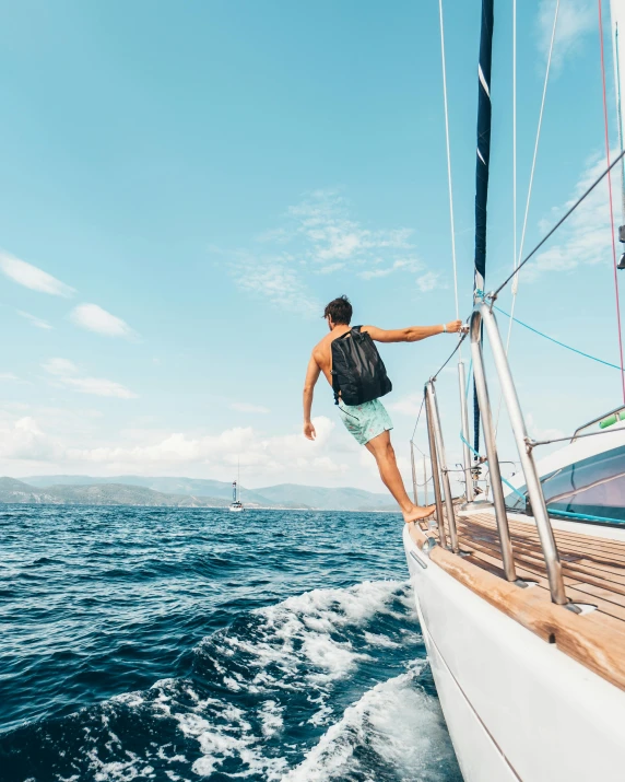 a man standing on the deck of a sailboat, pexels contest winner, happening, jumping towards viewer, a man wearing a backpack, thumbnail, slightly tanned