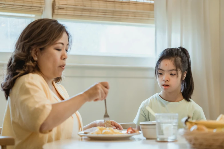 a woman and a child sitting at a table eating, pexels contest winner, manuka, avatar image, asian female, background image