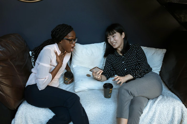 a couple of women sitting on top of a bed, inspired by Wang Duo, trending on unsplash, npc talking, on a coffee table, panel of black, low quality photo