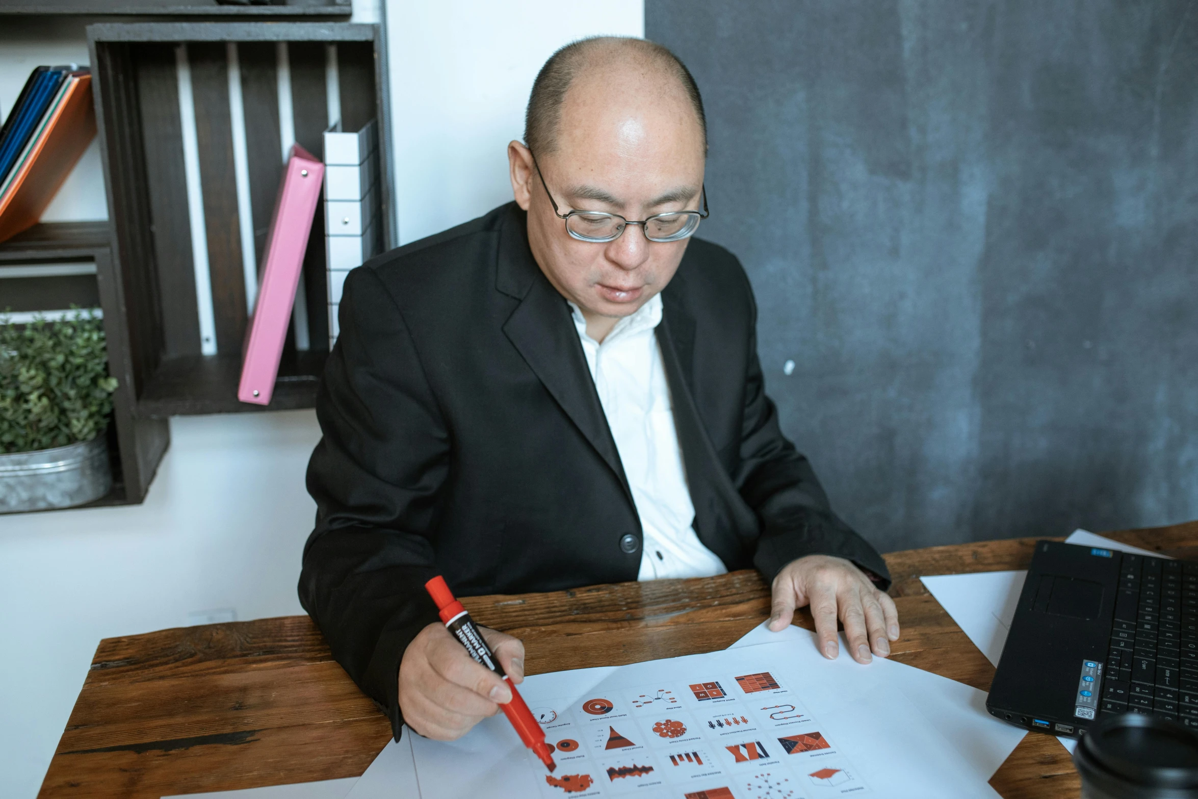 a man sitting at a desk writing on a piece of paper, a cartoon, pexels contest winner, gutai group, dzung phung dinh, academy headmaster, 🦑 design, drawing pictures on a notebook